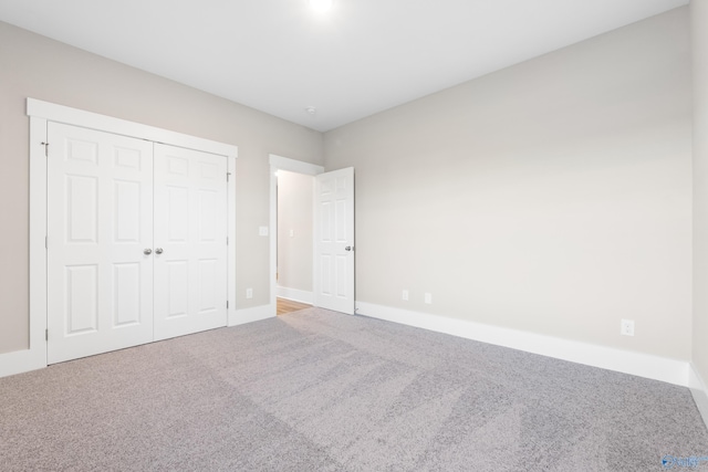 unfurnished bedroom with a closet, carpet, and baseboards