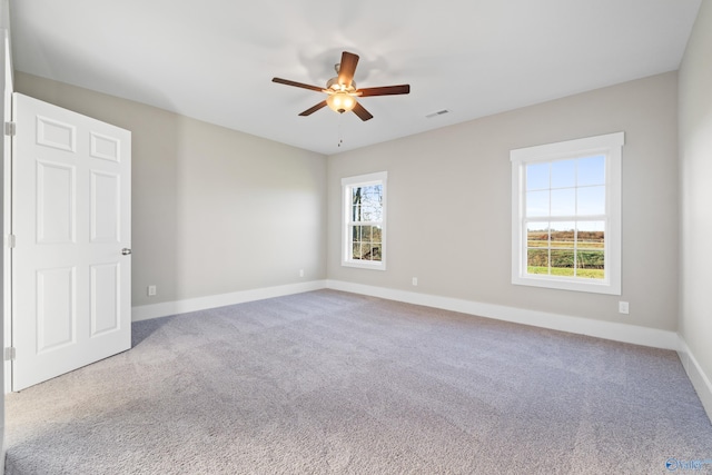unfurnished room with a ceiling fan, carpet floors, and baseboards