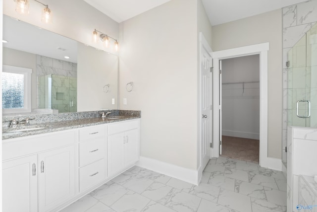 full bathroom with baseboards, a stall shower, marble finish floor, and a sink