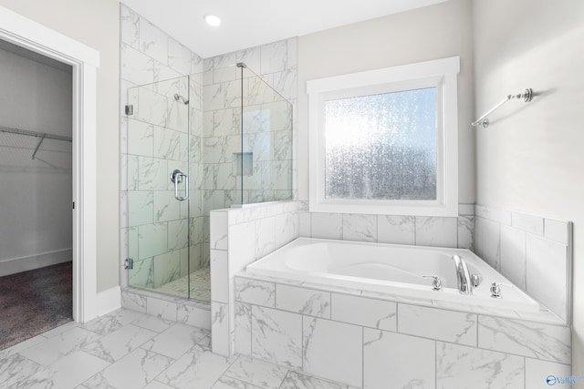 bathroom featuring a stall shower, baseboards, a garden tub, marble finish floor, and a walk in closet