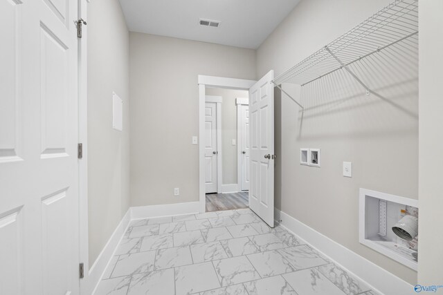 washroom featuring hookup for a washing machine, marble finish floor, laundry area, and baseboards