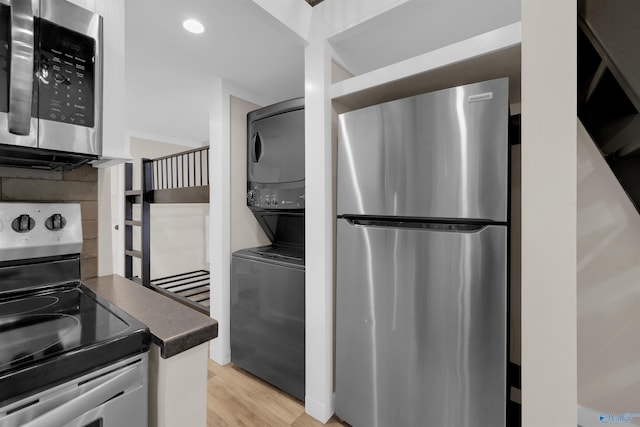 568 County Road 642, Mentone, AL 35984 - kitchen with appliances with stainless steel finishes, stacked washer and clothes dryer, dark countertops, and light wood finished floors