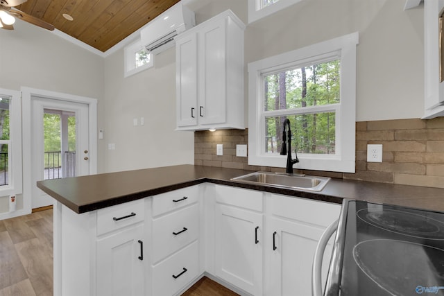 568 County Road 642, Mentone, AL 35984 - kitchen with range with electric stovetop, a sink, an AC wall unit, wood ceiling, and decorative backsplash