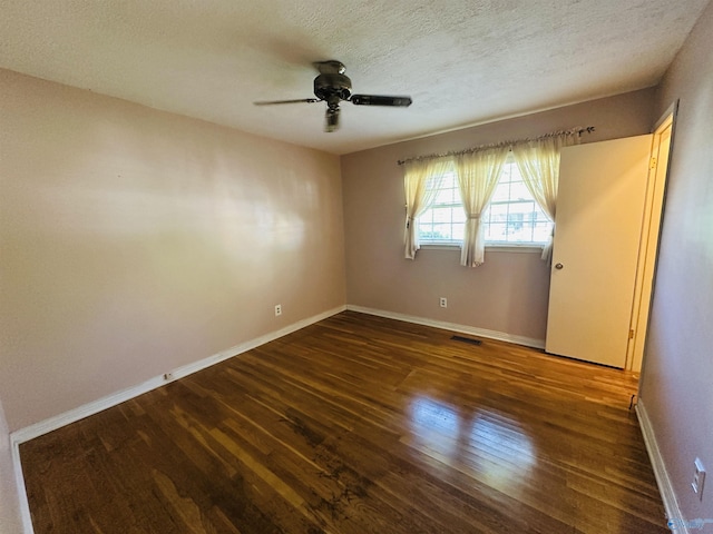 spare room featuring visible vents, wood finished floors, baseboards, ceiling fan, and a textured ceiling