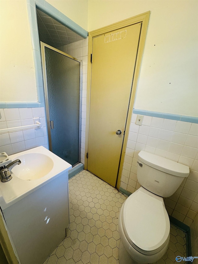 bathroom featuring wainscoting, tile walls, and a shower stall