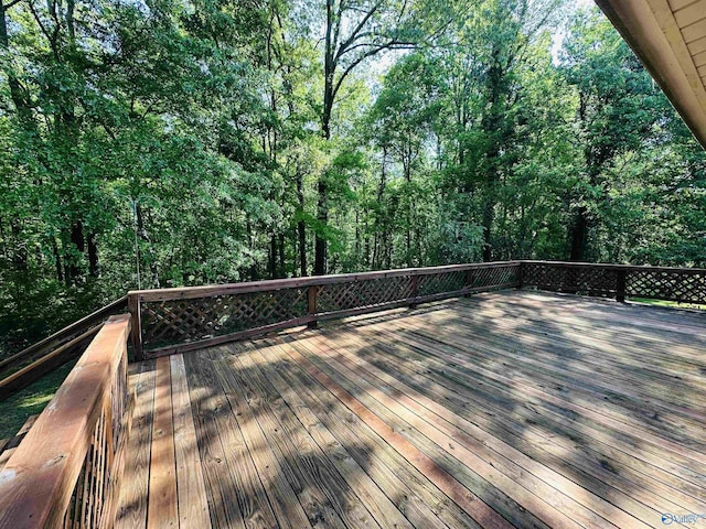 wooden terrace featuring a wooded view