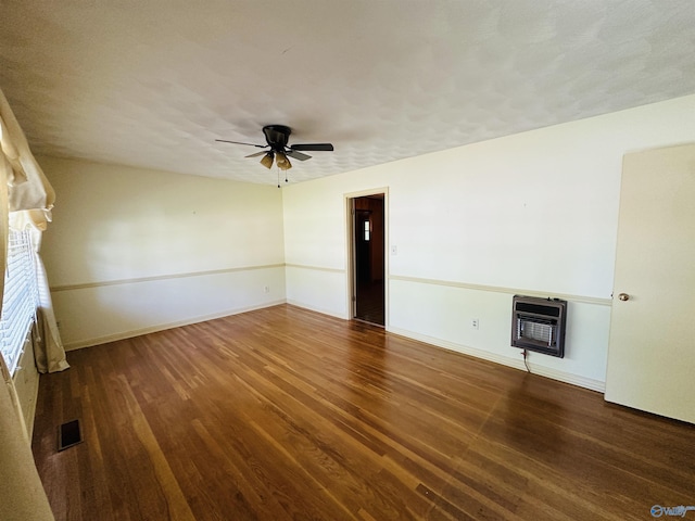unfurnished living room with visible vents, heating unit, and wood finished floors