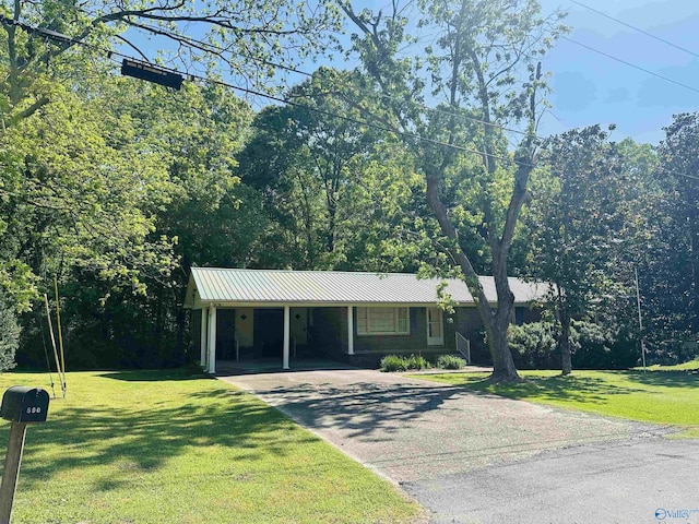 single story home featuring metal roof, driveway, and a front lawn
