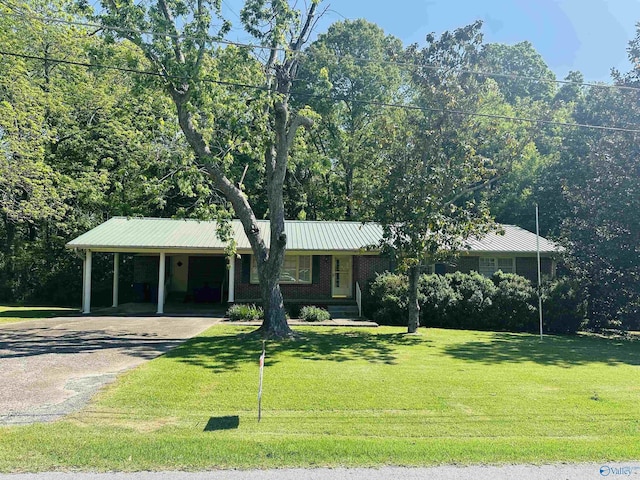 single story home featuring an attached carport, aphalt driveway, a front yard, and metal roof