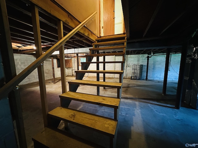 staircase with unfinished concrete floors