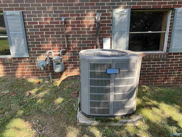 details featuring gas meter, central AC, and brick siding