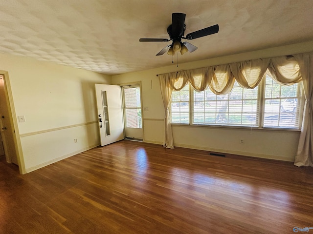 unfurnished room featuring baseboards, ceiling fan, visible vents, and wood finished floors