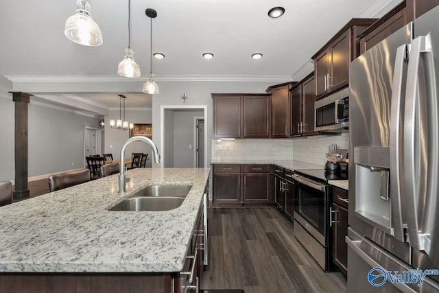 kitchen with stainless steel appliances, dark wood-style flooring, a sink, an island with sink, and crown molding