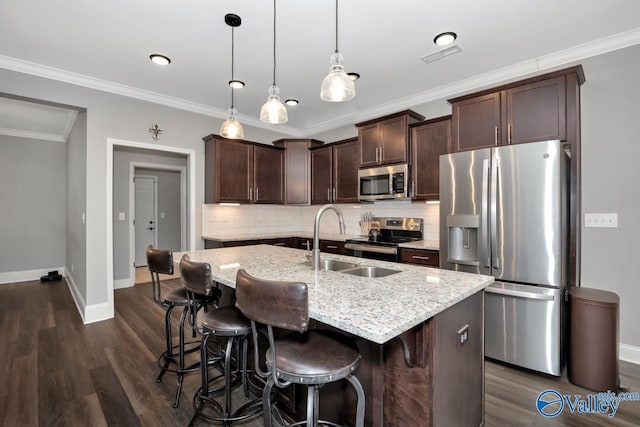 kitchen with dark brown cabinetry, appliances with stainless steel finishes, dark wood finished floors, and a sink