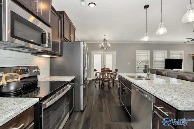 kitchen with appliances with stainless steel finishes, crown molding, a sink, and dark brown cabinets