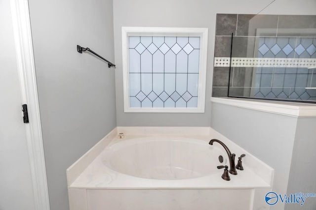 bathroom with a walk in shower and a garden tub