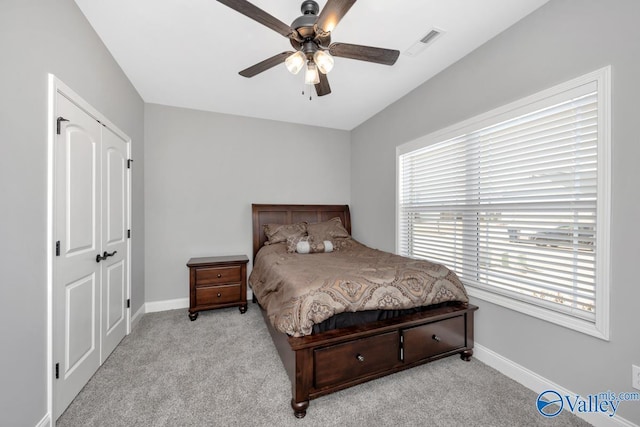 carpeted bedroom featuring ceiling fan, visible vents, and baseboards