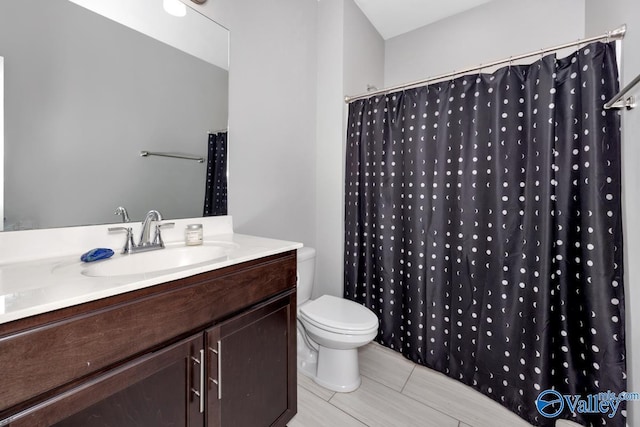 bathroom with curtained shower, vanity, and toilet