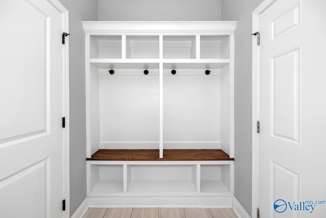 mudroom featuring light wood finished floors and baseboards