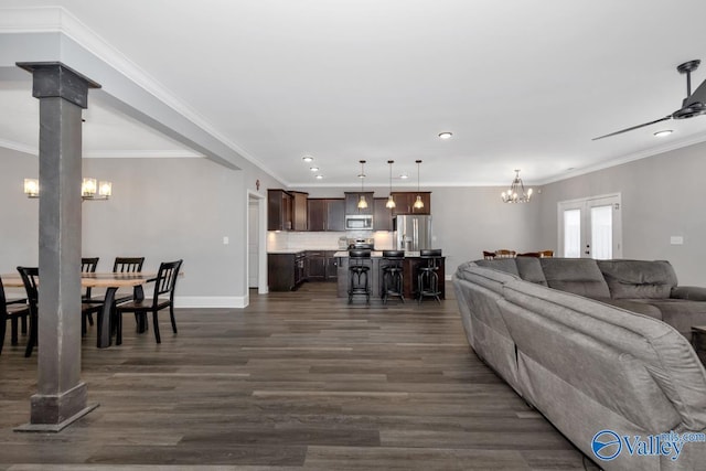 living room featuring crown molding, decorative columns, recessed lighting, dark wood-type flooring, and baseboards