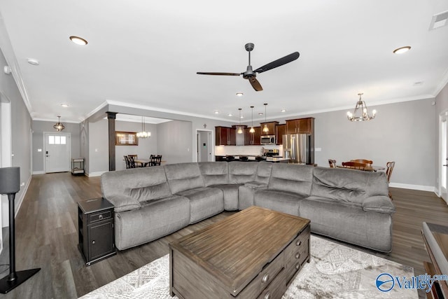 living room featuring ceiling fan with notable chandelier, baseboards, dark wood-style flooring, and ornamental molding