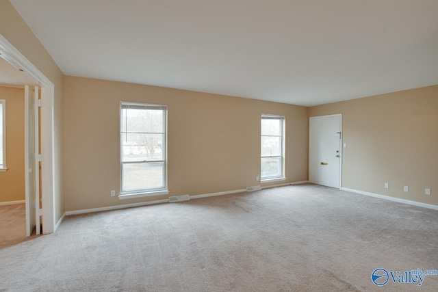 unfurnished room featuring carpet floors, baseboards, and visible vents