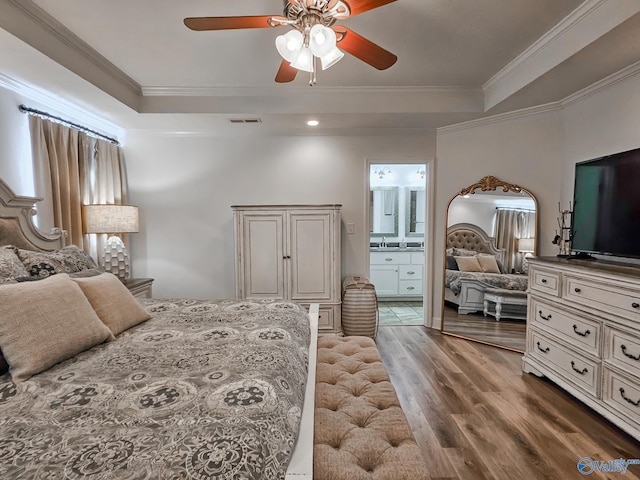 bedroom with ornamental molding, ensuite bath, hardwood / wood-style flooring, and ceiling fan