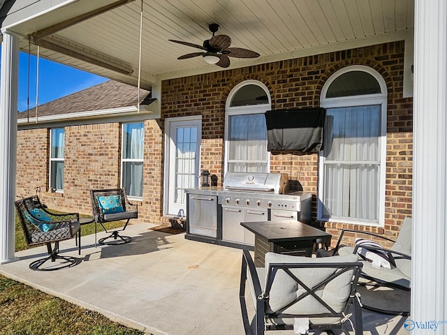 view of patio / terrace featuring ceiling fan, a grill, and exterior kitchen