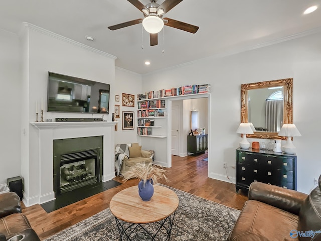 living room with crown molding, dark hardwood / wood-style flooring, and ceiling fan