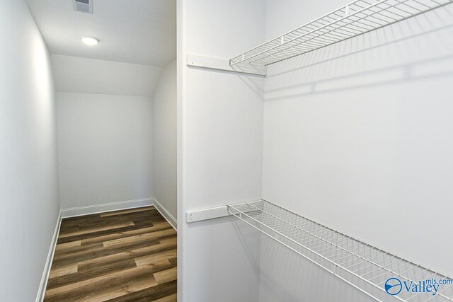 walk in closet with dark hardwood / wood-style flooring