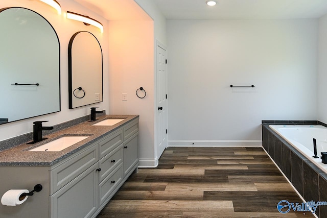 bathroom featuring vanity, hardwood / wood-style flooring, and a bathtub