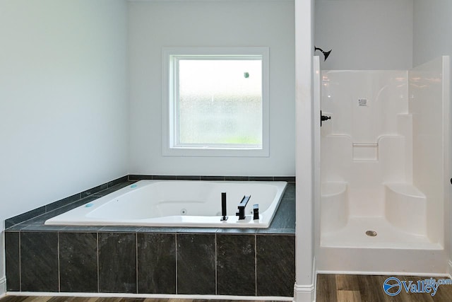 bathroom with wood-type flooring and shower with separate bathtub