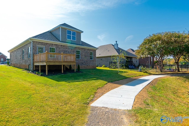 rear view of house with a yard and a deck