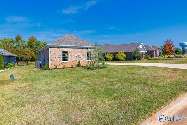 ranch-style home featuring a front lawn and central air condition unit