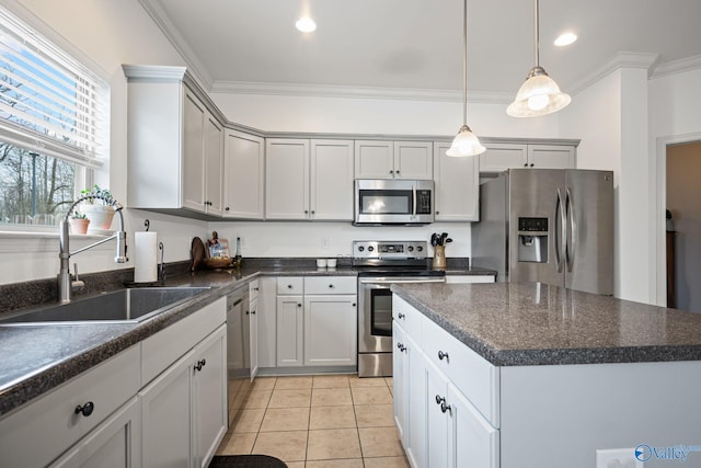 kitchen featuring light tile patterned flooring, appliances with stainless steel finishes, sink, a center island, and crown molding