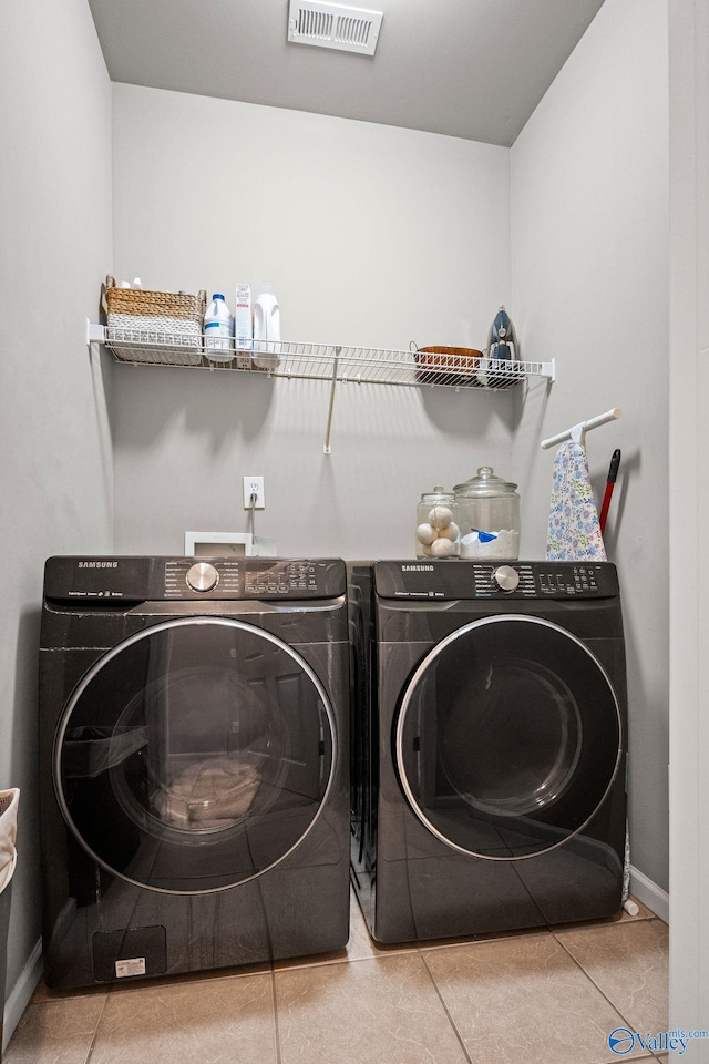 washroom with washer and dryer and light tile patterned floors