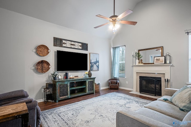 living room with hardwood / wood-style flooring, ceiling fan, and vaulted ceiling