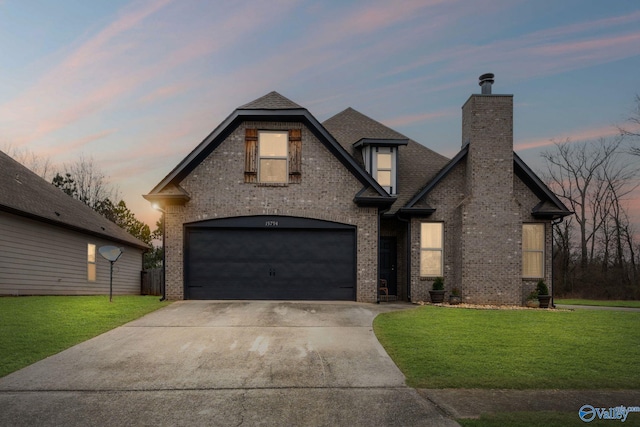 view of front of property with a garage and a lawn