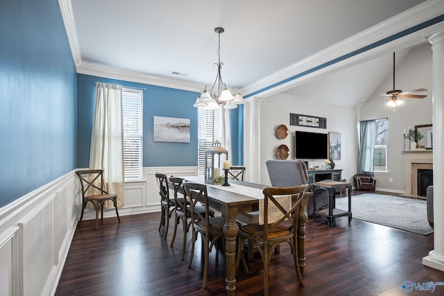 dining space featuring ornate columns, dark hardwood / wood-style floors, lofted ceiling, ornamental molding, and ceiling fan