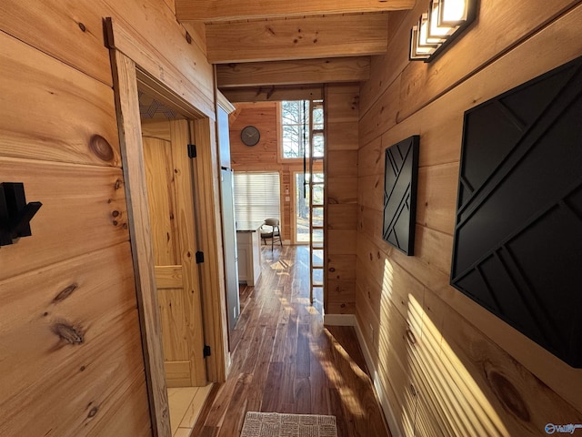 hallway featuring wooden walls, beamed ceiling, and dark hardwood / wood-style floors