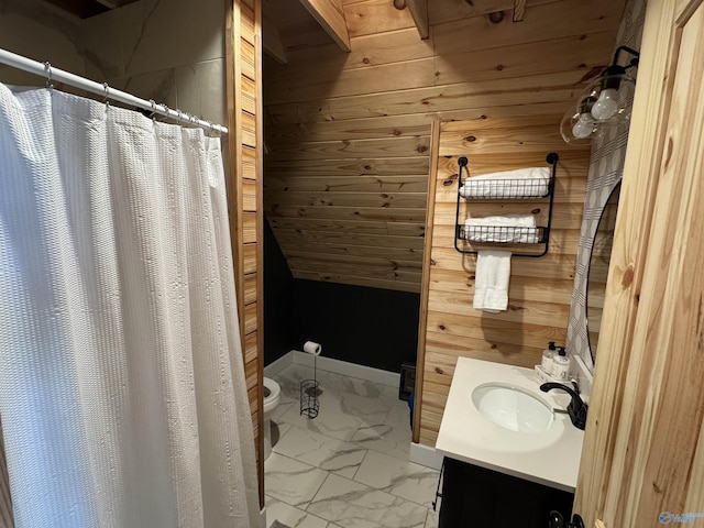 bathroom with vanity, toilet, and wooden walls