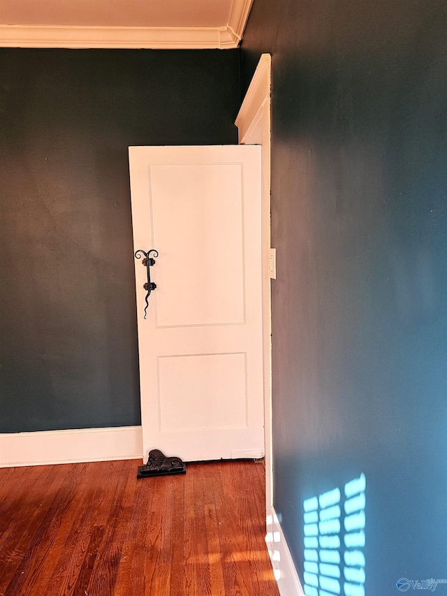 hallway featuring hardwood / wood-style floors and ornamental molding