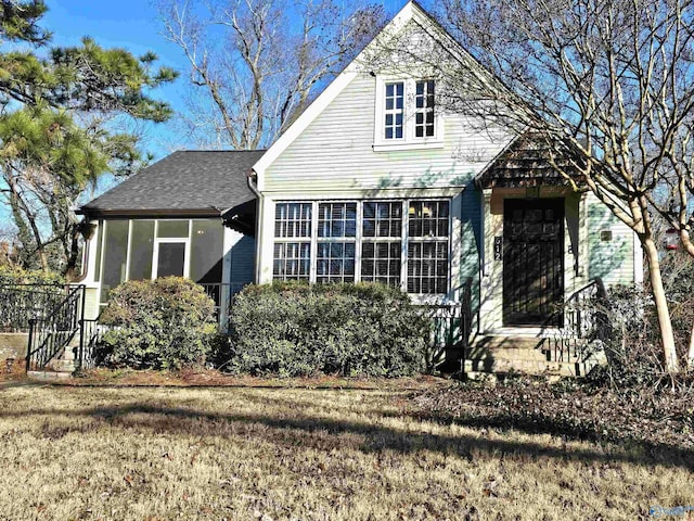 view of front of home with a front lawn and a sunroom