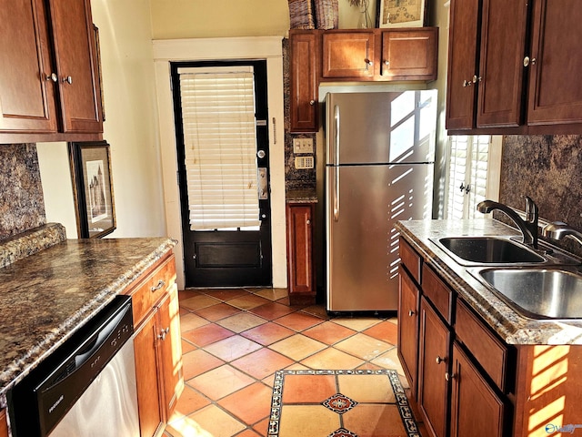 kitchen with sink, backsplash, light tile patterned floors, and stainless steel appliances