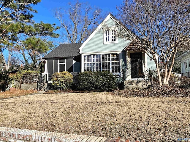 view of front of property featuring a front yard and a sunroom