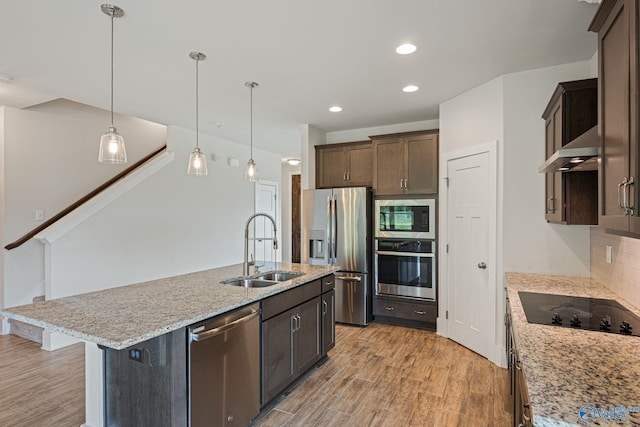 700 Magnolia Place Ln SW, Hartselle, AL 35640 - kitchen with appliances with stainless steel finishes, a sink, wall chimney exhaust hood, light wood-style flooring, and recessed lighting