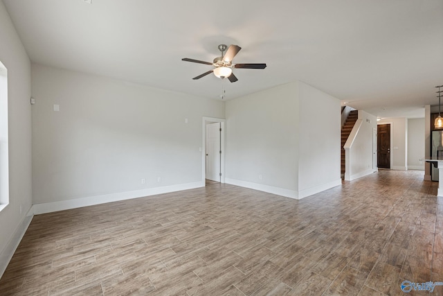 700 Magnolia Place Ln SW, Hartselle, AL 35640 - spare room featuring wood finished floors, a ceiling fan, baseboards, and stairs