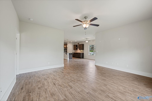 700 Magnolia Place Ln SW, Hartselle, AL 35640 - unfurnished living room with ceiling fan, light wood finished floors, and baseboards