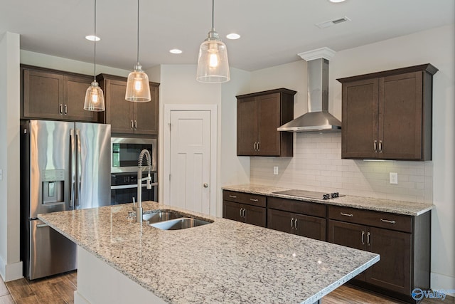 700 Magnolia Place Ln SW, Hartselle, AL 35640 - kitchen featuring stainless steel appliances, wall chimney range hood, dark brown cabinets, dark wood-type flooring, and an island with sink