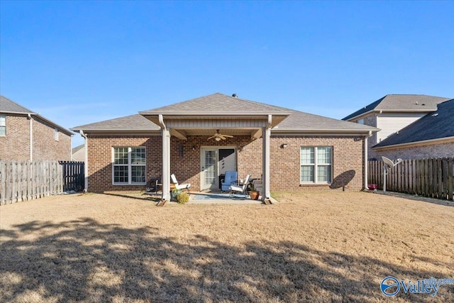 back of property featuring ceiling fan, a patio, and a lawn